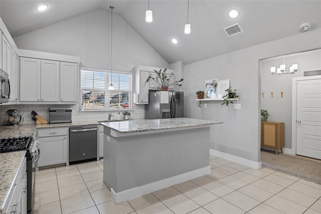 kitchen with white cabinetry, a center island, tasteful backsplash, pendant lighting, and appliances with stainless steel finishes