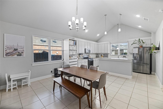 tiled dining space with high vaulted ceiling and a chandelier