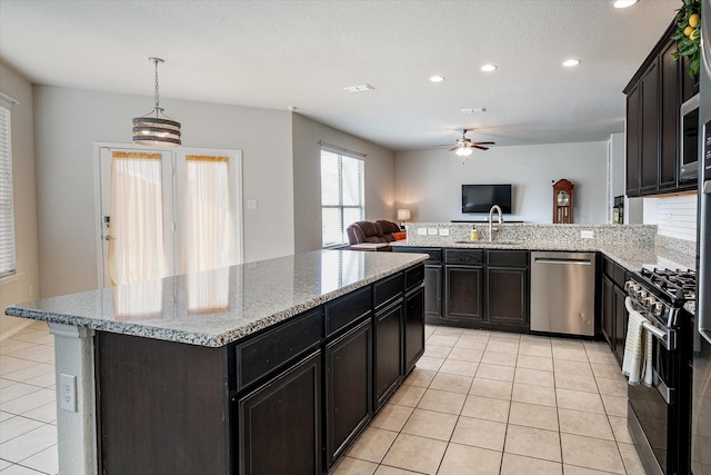 kitchen featuring pendant lighting, ceiling fan with notable chandelier, light tile patterned floors, and appliances with stainless steel finishes