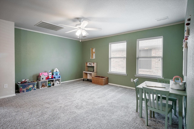 recreation room with carpet, ceiling fan, and crown molding