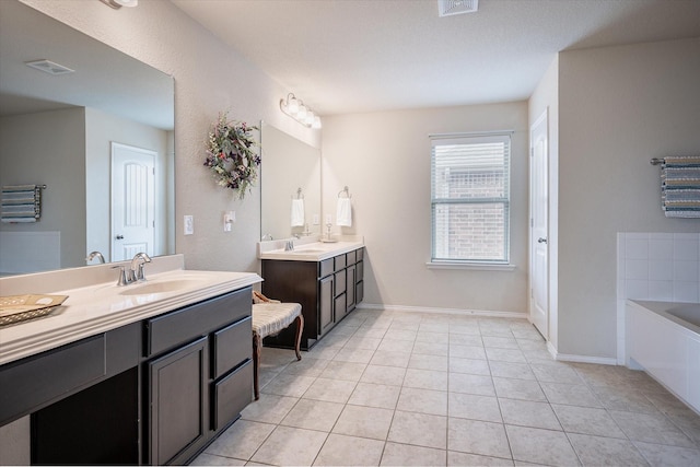 bathroom featuring tile patterned flooring, vanity, and a washtub