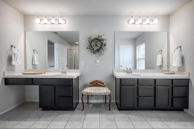 bathroom with tile patterned floors, vanity, and walk in shower