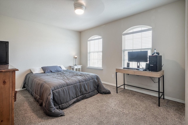 carpeted bedroom featuring multiple windows and ceiling fan