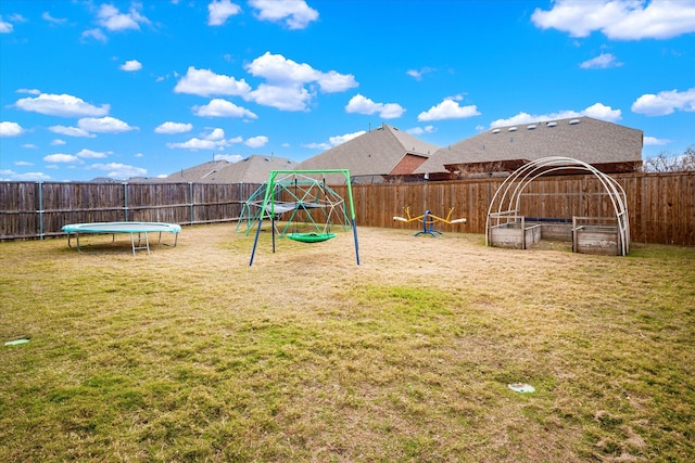 view of yard featuring a playground and a trampoline