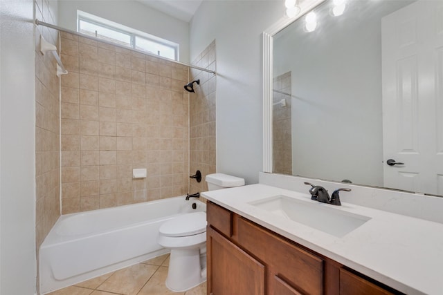 full bathroom with tile patterned floors, vanity, tiled shower / bath combo, and toilet