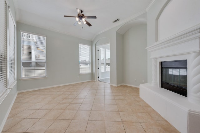 unfurnished living room with light tile patterned floors, ceiling fan, and ornamental molding