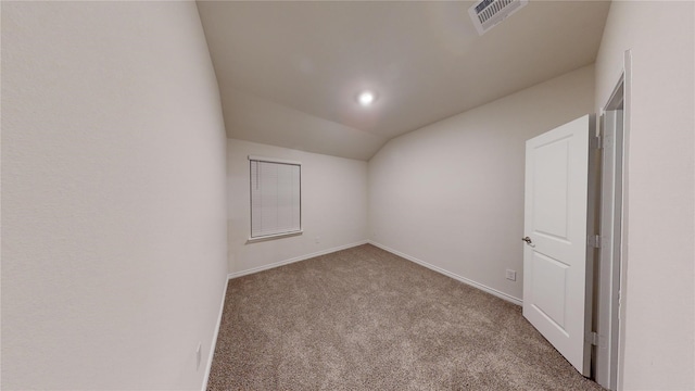 carpeted empty room with vaulted ceiling