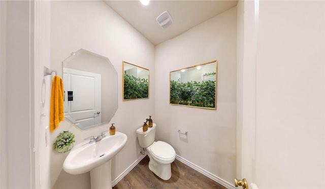 bathroom with hardwood / wood-style flooring, toilet, and sink