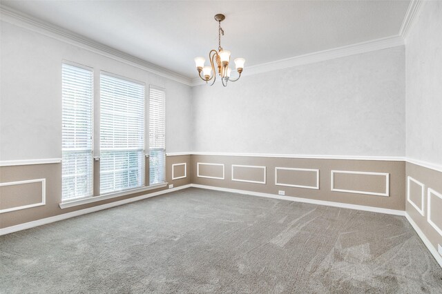 carpeted empty room with a wealth of natural light, crown molding, and a chandelier