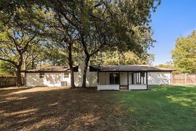 rear view of house featuring a yard and central AC unit