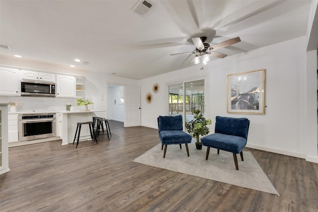 living area featuring dark hardwood / wood-style flooring and ceiling fan