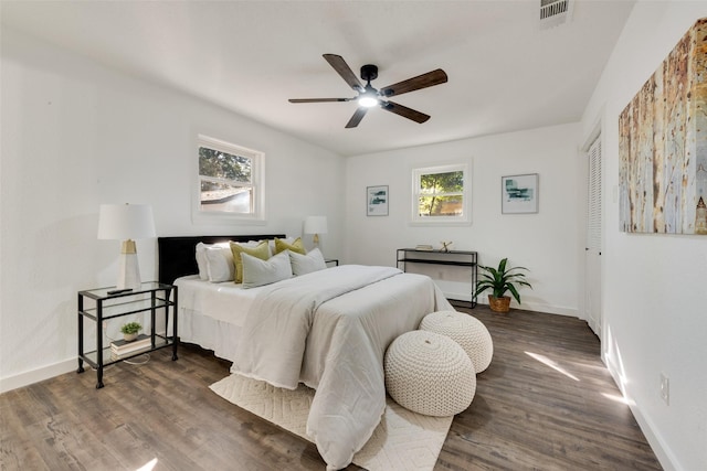 bedroom with multiple windows, dark hardwood / wood-style flooring, a closet, and ceiling fan