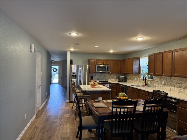 kitchen featuring a center island, sink, stainless steel appliances, and a wealth of natural light