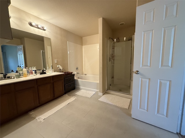 bathroom with tile patterned floors, vanity, separate shower and tub, and a textured ceiling