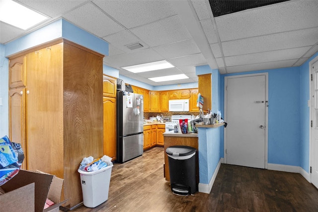 kitchen with kitchen peninsula, decorative backsplash, white appliances, and a paneled ceiling