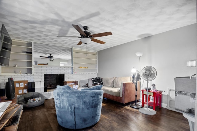 living room featuring dark hardwood / wood-style floors and a brick fireplace