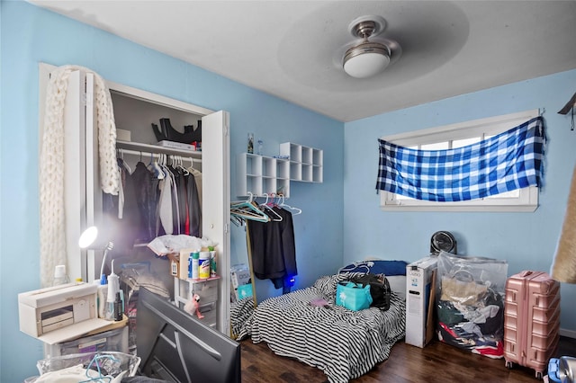 bedroom with ceiling fan, dark hardwood / wood-style flooring, and a closet