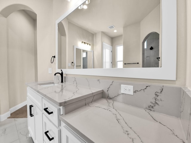 bathroom with vanity and a shower