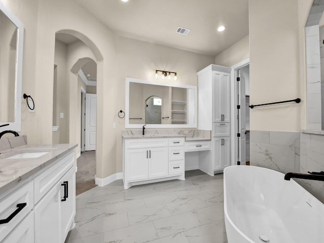 bathroom with vanity and a tub to relax in