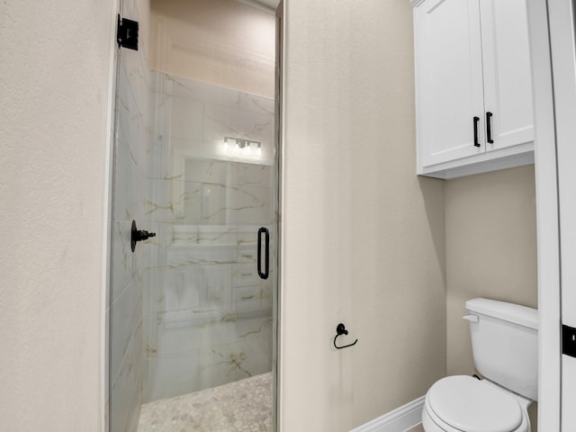 bathroom featuring toilet and a shower with door