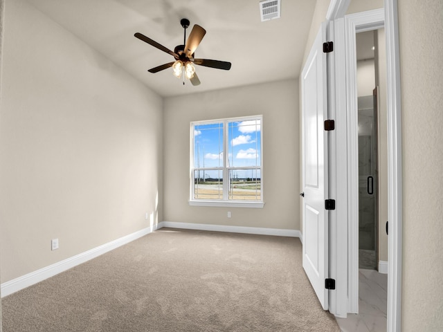 carpeted spare room with ceiling fan