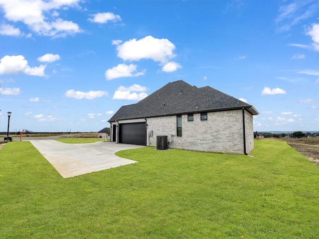 back of property featuring a lawn, a patio area, central AC unit, and a garage