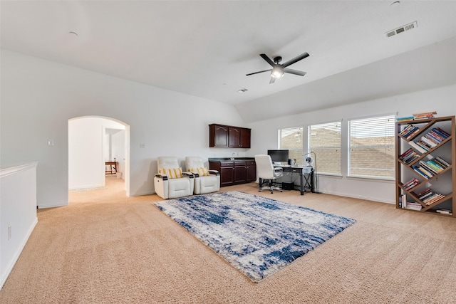 carpeted office space with vaulted ceiling and ceiling fan