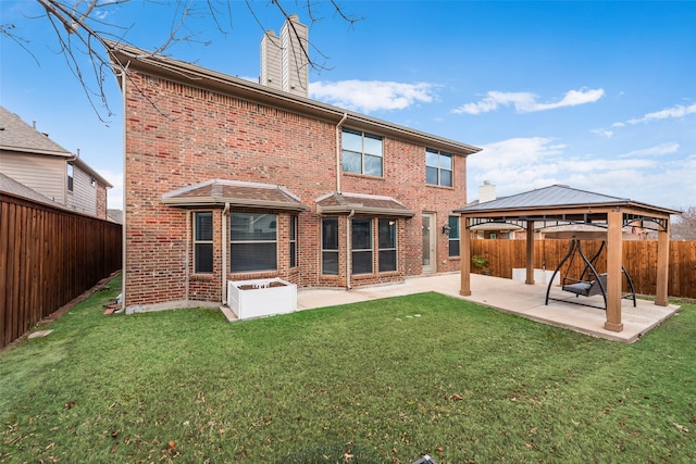 rear view of property featuring a gazebo, a lawn, and a patio