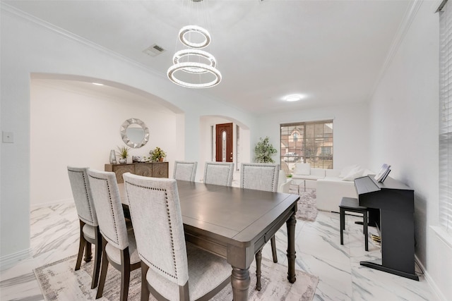 dining space with crown molding and an inviting chandelier