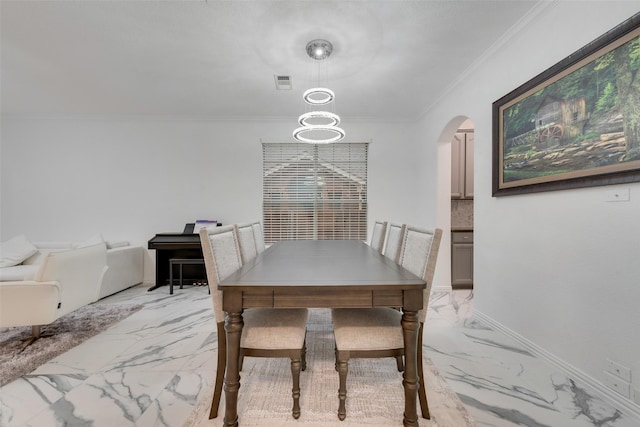 dining area with an inviting chandelier and ornamental molding