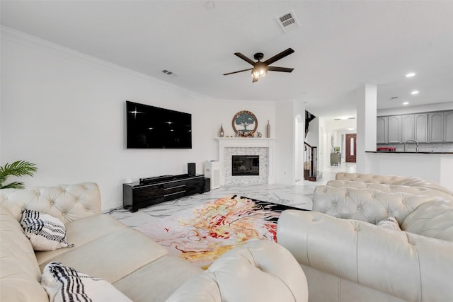 living room with ceiling fan and ornamental molding