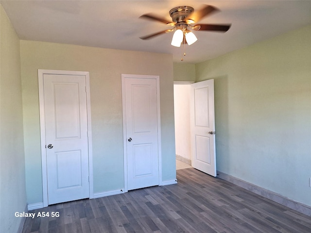 unfurnished bedroom featuring ceiling fan and dark hardwood / wood-style flooring