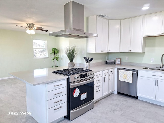 kitchen featuring sink, appliances with stainless steel finishes, kitchen peninsula, island exhaust hood, and white cabinets