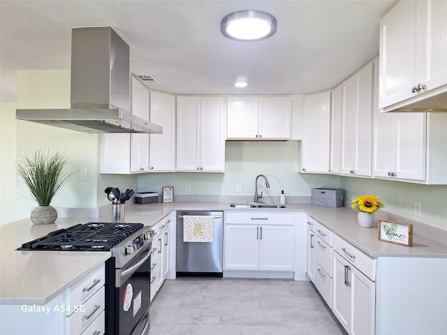 kitchen featuring white cabinets, wall chimney range hood, sink, light stone countertops, and stainless steel appliances