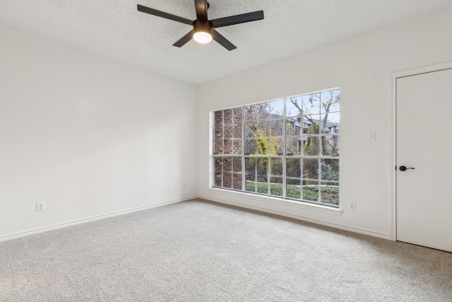 spare room with carpet flooring, ceiling fan, a healthy amount of sunlight, and a textured ceiling