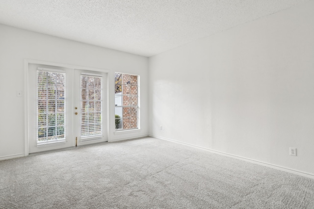 carpeted spare room with a textured ceiling