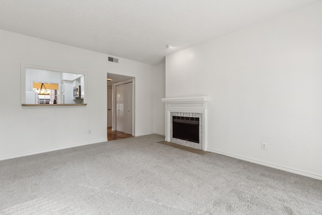 unfurnished living room featuring carpet floors, a fireplace, and a chandelier