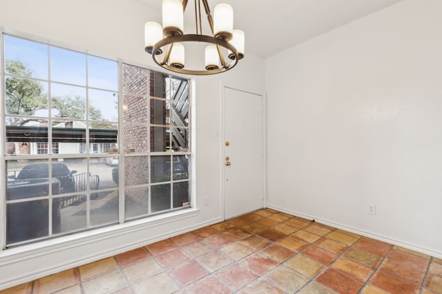 unfurnished dining area with tile patterned flooring, a notable chandelier, and plenty of natural light