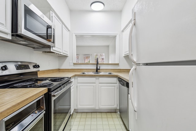 kitchen featuring sink, white cabinets, a textured ceiling, and appliances with stainless steel finishes