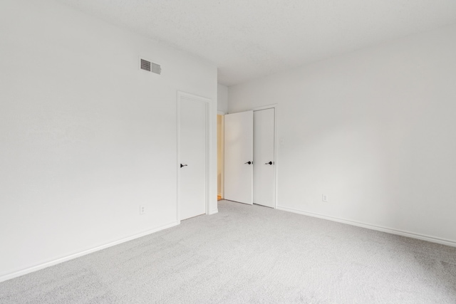 spare room featuring light colored carpet