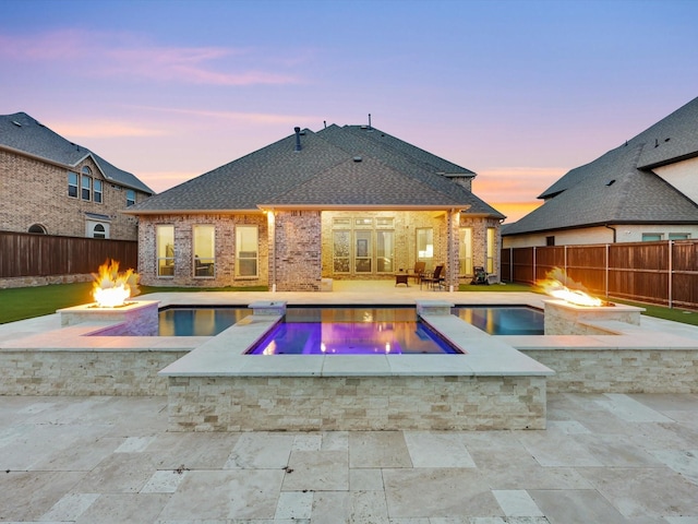 view of swimming pool with a patio, a fire pit, a fenced backyard, and a pool with connected hot tub