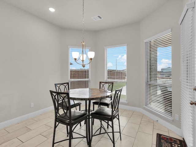 tiled dining room with a chandelier