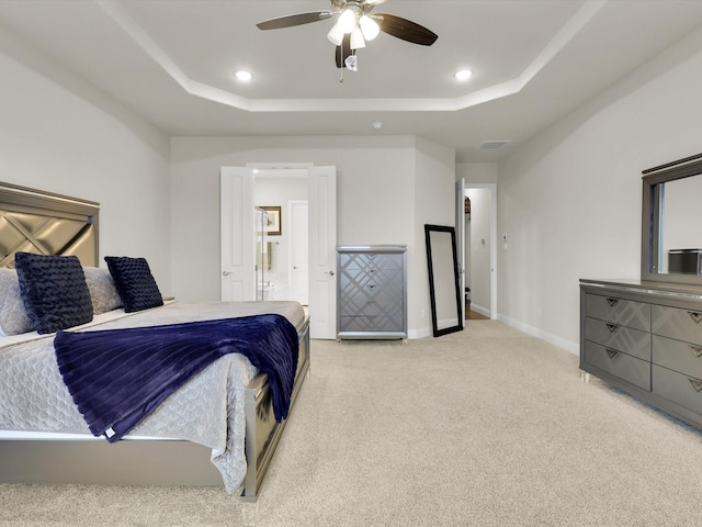 bedroom featuring baseboards, visible vents, a raised ceiling, and light carpet