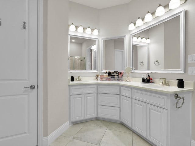 bathroom with double vanity, tile patterned flooring, a shower with shower door, and a sink