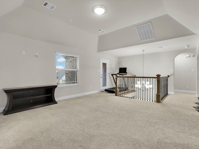 interior space with light carpet, vaulted ceiling, and an inviting chandelier