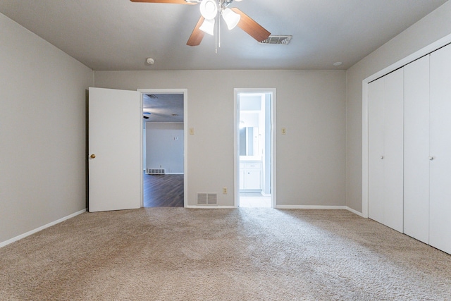 unfurnished bedroom with carpet flooring, connected bathroom, a closet, and ceiling fan