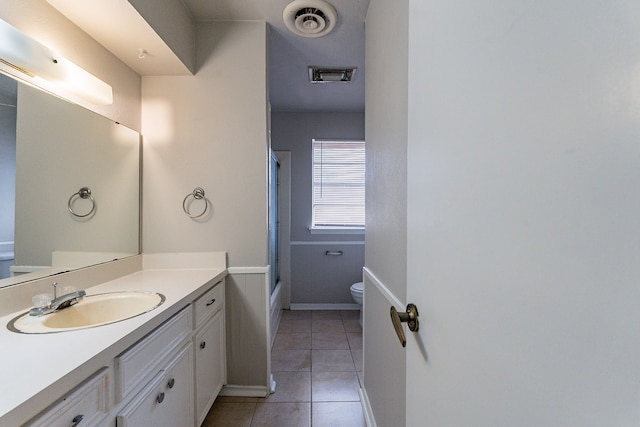 full bathroom featuring tile patterned floors, vanity, toilet, and shower / bath combination with glass door