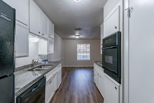 kitchen with dark wood-type flooring, dark stone counters, black appliances, sink, and white cabinetry