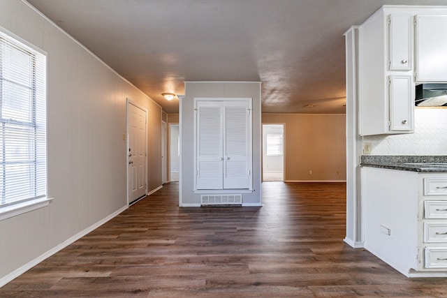 interior space with white cabinets, decorative backsplash, dark hardwood / wood-style flooring, and extractor fan