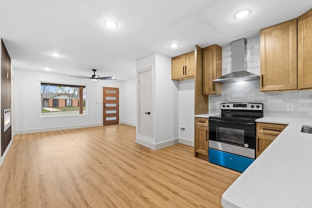 kitchen with tasteful backsplash, electric range, light wood-type flooring, ceiling fan, and wall chimney range hood